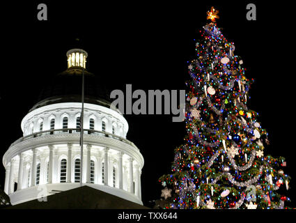 Das State Capitol Weihnachtsbaum steht vor dem State Capitol leuchtet auf, nachdem der Gouverneur von Kalifornien, Arnold Schwarzenegger, der Baum auf dem 74. jährlichen State Capitol Weihnachtsbaum Zeremonie in Sacramento, Kalifornien am 6.Dezember 2005 beleuchtet. Baum in diesem Jahr ist ein 55-Fuß-weiße Douglasie von El Dorado County, mit etwa 6.500 LED-Lichtern geschmückt. Diese Leuchten sparen 95 Prozent der Energie für den Baum. (UPI Foto/Ken James) Stockfoto