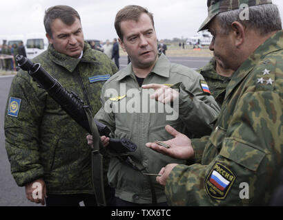 Der russische Präsident Dmitri Medwedew (C) in Begleitung von Verteidigungsminister Anatolij Serdjukow (L) hält einen Unterwasser Maschinengewehr als beobachtet er Th strategische militärische Übungen Zapad-2009 (West 2009), an der Khmelevka Training Strecke in der Region Kaliningrad auf der Ostsee am 28. September 2009. UPI/Anatoli Zhdanov Stockfoto