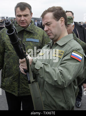 Der russische Präsident Dmitri Medwedew (R) begleitet von Verteidigungsminister Anatolij Serdjukow hält eine Unterwasser Maschinengewehr als beobachtet er die strategische militärische Übungen Zapad-2009 (West 2009), an der Khmelevka Training Strecke in der Region Kaliningrad auf der Ostsee am 28. September 2009. UPI/Anatoli Zhdanov Stockfoto