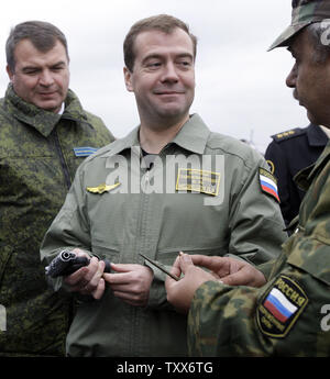 Der russische Präsident Dmitri Medwedew (C) in Begleitung von Verteidigungsminister Anatolij Serdjukow (L) eine Waffe während einer strategischen militärischen Übungen Zapad-2009 (West 2009) an der Khmelevka Training Strecke in der Region Kaliningrad an der Ostsee hält am 28. September 2009. UPI/Anatoli Zhdanov Stockfoto