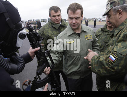 Der russische Präsident Dmitri Medwedew (C) in Begleitung von Verteidigungsminister Anatolij Serdjukow (L) hält einen Unterwasser Maschinengewehr als beobachtet er Th strategische militärische Übungen Zapad-2009 (West 2009), an der Khmelevka Training Strecke in der Region Kaliningrad auf der Ostsee am 28. September 2009. UPI/Anatoli Zhdanov Stockfoto