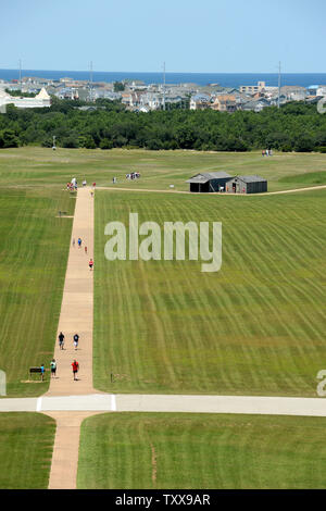 Der Atlantik ist die Kulisse für den National Park Service Wright Brothers National Memorial in Kill Devil Hills in der Nähe von Kitty Hawk auf den Outer Banks von North Carolina am 25. Juli 2015. Orville und Wilbur Wright haben Ihr segelflugzeug Tests von 1900 und flog ersten Flugzeug der Welt an diesem langen Sandstrand am 17. Dezember 1903. Repliken der Brüder Wohn- und Flugzeug Aufhängung oben rechts mit dem Flugzeug gesehen werden können. Denkmal auf der linken Seite. Der erste Flug reisten 120 Fuß und dauerte 12 Sekunden. Foto von Pat Benic/UPI Stockfoto