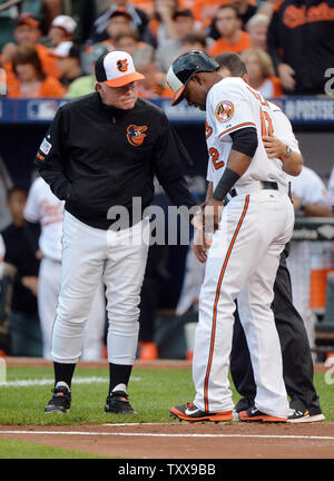 Baltimore Orioles Manager Buck Showalter (L) prüft auf Alejandro De Aza nach De Aza von einem Pitch im ersten Inning von Spiel 1 der American League Division Series gegen die Detroit Tigers auf Orioles Park geschlagen wurde in Camden Yards, Baltimore, Maryland am 2. Oktober 2014. UPI/Kevin Dietsch Stockfoto