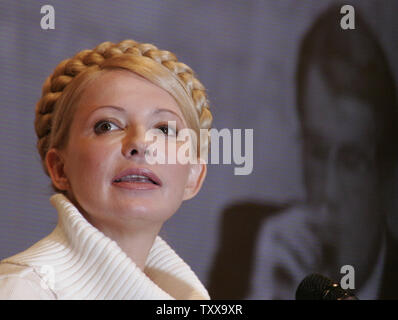 Ehemalige ukrainische Premierministerin Julia Timoschenko Kommentare eine aktuelle Nachrichten Konferenz der Ukrainische Präsident Viktor Juschtschenko am TV-Bildschirm im Hintergrund in Kiew, 21. März 2006. Am 26. März etwa 45 politischen Parteien werden für die ukrainischen Parlamentswahlen laufen. (UPI Foto/Sergey Starostenko) Stockfoto