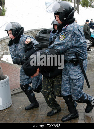 Riot Polizisten verhaften ein anti-kommunistische Demonstranten auf einer Kundgebung zum Gedenken an den Jahrestag der bolschewistischen Revolution in Kiew am 7. November 2006. Zusammenstößen zwischen der Polizei und anti-kommunistische Demonstranten in Kiew am Dienstag, wenn einige nationalistischen Gegner versucht, eine kommunistische Rally Kennzeichnung der 89. Jahrestag der bolschewistischen Revolution zu stören. (UPI Foto/Sergey Starostenko). Stockfoto