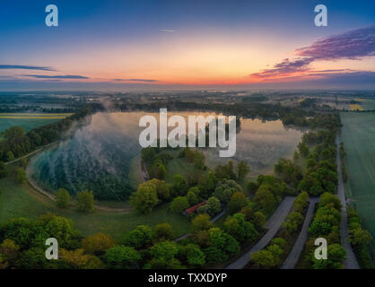 Nebliger Sonnenaufgang am frühen Morgen an einem See Stockfoto