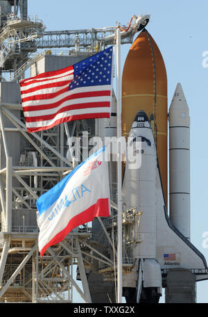 Das Space Shuttle Atlantis STS 132 ist von der rotierenden Service Struktur nach dem Rollback am 13. Mai 2010 in der Vorbereitung für den Start am 14. Mai 2010 im Kennedy Space Center, Florida gelöscht. Atlantis wird seinen letzten geplanten Start morgen machen. Die amerikanische und die Atlantis Fahnen wehen im Vordergrund. UPI/Pat Benic Stockfoto