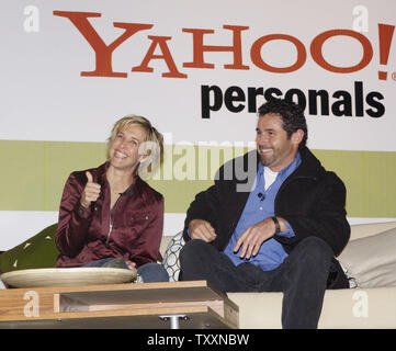 Julie Koehnen (L) von Los Angeles gibt einen Daumen nach oben, als Sie und Rennen Automechaniker Clark Drake für ihr Datum auf einem Plakat auf dem Sunset Strip in Los Angeles, Kalifornien, den 9. Januar 2004. Julie ausgewählten acht Männer im Laufe der drei Tage von Yahoo! Kontaktanzeigen über eine drahtlose Verbindung mit dem Internet, von Angesicht zu Angesicht auf der Anschlagtafel zu treffen, bevor sie Drake für ihre abschließenden Datum. (UPI/Jim Ruymen) Stockfoto