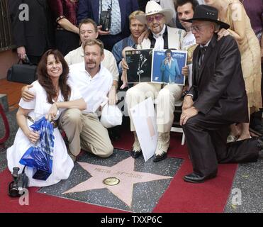 Entertainer Herb Jeffries (C) sitzt, umgeben von Freunden und Familienmitgliedern, einschließlich seiner Frau Savannah (L), wie er mit dem 2.263 rd Stern auf dem Hollywood Walk of Fame geehrt wird während einer enthüllungsfeier in Los Angeles, Kalifornien, 24. September 2004. Jeffries, 93, wurde in der Tradition von Gene Autry und Roy Rogers, ein Hollywood erstellt, Silver Screen, singenden Cowboy Held, werden der erste und einzige schwarze/Lead in Western. Einer seiner bekanntesten Songs war ein Tune namens "Flamingo" (UPI Foto/Jim Ruymen) Stockfoto