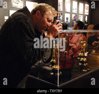 Ein Besucher nimmt ein Bild von einigen der 50 Oscar Statuetten auf Anzeige am letzten Tag der Ausstellung Treffen die Oscars in Hollywood" in Los Angeles, Kalifornien, 3. März 2006. Die Ausstellung zeigt Fotografien aus früheren Academy Awards, den Oscar gewonnen von Clark Gable für seine Rolle in "Mit Dem Wind" und die 50 Oscars, die Gewinner am 78. jährliche Oscar-Verleihung in Hollywood am 5. März vorgelegt werden soll. (UPI Foto/Jim Ruymen) Stockfoto