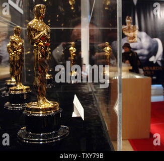 Besucher schauen Sie über einige der 50 Oscar Statuetten auf Anzeige am letzten Tag der Ausstellung Treffen die Oscars in Hollywood" in Los Angeles, Kalifornien, 3. März 2006. Die Ausstellung zeigt Fotografien aus früheren Academy Awards, den Oscar gewonnen von Clark Gable für seine Rolle in "Mit Dem Wind" und die 50 Oscars, die Gewinner am 78. jährliche Oscar-Verleihung in Hollywood am 5. März vorgelegt werden soll. (UPI Foto/Jim Ruymen) Stockfoto