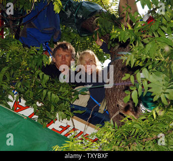 Schauspielerin und Fürsprecher für Umweltgerechtigkeit Daryl Hannah (R) und Aktivist John Quigly sitzen in den Filialen der Nußbaum am 14 Hektar großen städtischen Bauernhof mit Abriss in Los Angeles, Kalifornien am 27. Mai 2006 bedroht. Die Demonstranten schworen, friedlich zu Vertreibung aus dem Garten von etwa 350 überwiegend armen, spanischer Familien, an dem die Grundbesitzer will ein Lager zu errichten gezüchtetem widerstehen. (UPI Foto/Jim Ruymen) Stockfoto