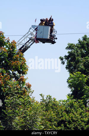 Schauspielerin Darryl Hannah (C) und Aktivist John Quigley (R) Geste, als sie von einem Nussbaum in einer städtischen Gemeinschaft Bauernhof von der Feuerwehr in South Central Los Angeles, Kalifornien am 13. Juni 2006 entfernt. Dutzende Menschen wurden verhaftet als Stellvertreter des Sheriffs Landwirte und Unterstützer aus der South Central Farm frühen Dienstag Morgen hinausgeworfen, die Durchsetzung einer gerichtlichen Anordnung durch den Eigentümer, wer will die Eigenschaft zu entwickeln. (UPI Foto/Jim Ruymen) Stockfoto