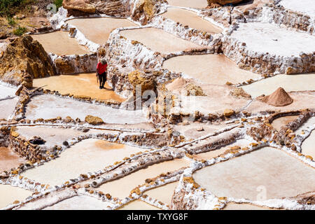Mann bei der Arbeit auf Salineras de Maras/Maras Salzminen. Die Salzgewinnung in Maras Salinen, Terrassen und Teichen, Peru Sacred Valley. Stockfoto