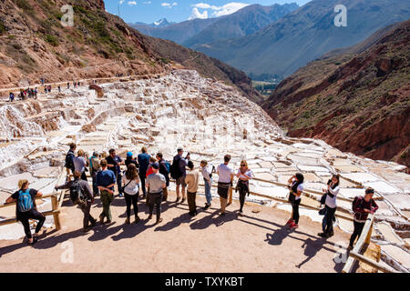 Touristen, die Salineras de Maras/Maras Salt Mines besuchen. Salzgewinnung in Maras Salzpfannen, Terrassen und Teichen, Massentourismus, Peru-Heiliger Tal. Stockfoto