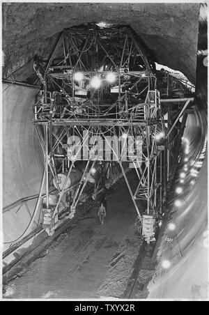 Konkrete Waffe Beförderung bei der Platzierung von 110 Grad top-arch Beton in der Abzweigung Tunnel verwendet; Umfang und Inhalt: Foto aus Band 2 einer Reihe von Fotoalben dokumentiert den Bau des Hoover Dam, Boulder City, Nevada. Vollständige Titelzeile des Foto liest: konkrete Waffe Beförderung bei der Platzierung von 110 Grad top-arch Beton in der Abzweigung Tunnels verwendet. Beton ist geschleppten Stapler im Dump-Eimer unter Beförderung zum oberen Deck von brückenkran Betrieb über den Kopf gehoben, in Trichter entleert und in Formen, die durch komprimierte Luft gezwungen durch zwei 8-Zoll Stahl und die Gummirohre. Zwei Gun Unit Stockfoto