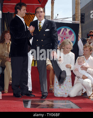 Der britische Schauspieler Sir Roger Moore (C) schüttelt sein Bein, wie seine Frau, die Schauspielerin Christina Tholstrup (3rd-L) und Sohn Geoffrey (L) unterstützen ihn, während eine enthüllungsfeier ihn ehrt mit dem 2.350 th Stern auf dem Hollywood des Ruhmes in Los Angeles am 11. Oktober 2007 laufen. Moore erschien im Jahr 1973 in seinem ersten James Bond Film "Leben und Sterben lassen.' Er auch die Hauptrolle als Simon Templar in der TV-Serie "The Saint" (UPI Foto/Jim Ruymen) Stockfoto