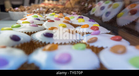 Brötchen mit bunten Smarties für Verkauf im Einzelhandel Vitrine Stockfoto