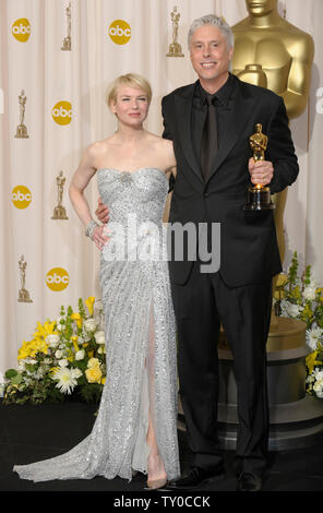 Christopher Rouse hält seinen Film bearbeiten Oscar für seine Arbeit an "The Bourne Ultimatum" bei den 80. Academy Awards in Hollywood am 24. Februar 2008. Moderator Renee Zellweger steht auf der linken Seite. (UPI Foto/Phil McCarten) Stockfoto