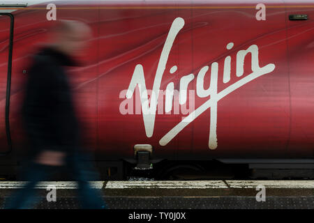 Ein Mann an der Jungfrau Logo wie auf der Seite von einem von der Firma Pendolino Züge gesehen. Stockfoto