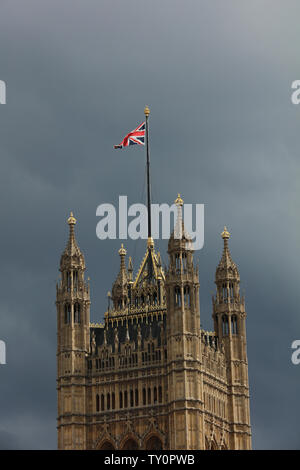 Turm mit einem Flag Pole und der Union Jack in der Sonne vor grauem Himmel in London, am Nachmittag im Monat Juni. Stockfoto