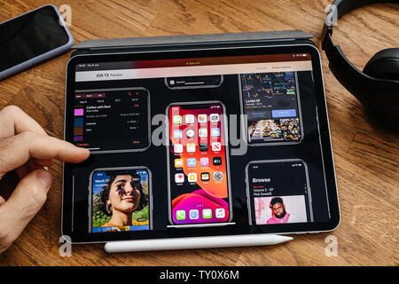Paris, Frankreich - Jul 6, 2019: der Mensch Lesen auf Apple iPad pro Tablette über neueste Ankündigung bei Apple Worldwide Developers Conference (WWDC) - Zeigt die mehrere Geräte mit Ios 13. Stockfoto