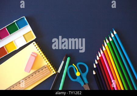 Schulbedarf auf dunkelblauem Hintergrund. Zurück zum Konzept der Schule. Flach, kopieren. Stockfoto