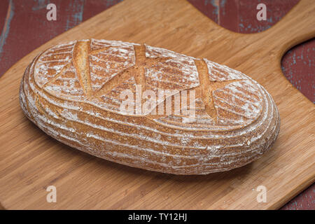 Laib Sauerteigbrot auf Holzbrett Stockfoto