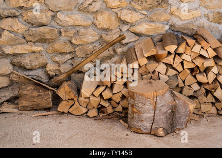 Stapel von Brennholz gegen die Mauer aus Stein von Bauernhaus Stockfoto