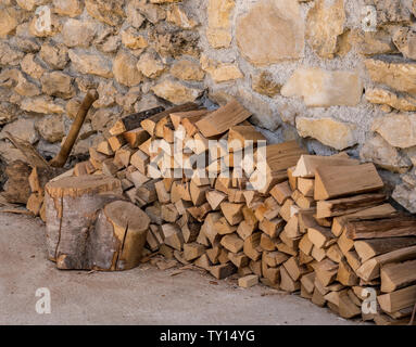 Stapel von Brennholz gegen die Mauer aus Stein von Bauernhaus Stockfoto