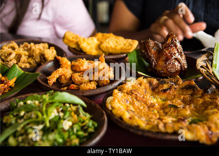 Lecker suchen indonesische Essen auf dem Tisch mit einer Vielzahl von Chili Saucen, Reis, Garnelen, Huhn und Omelette. Reisen und Essen Konzept Bild her Stockfoto