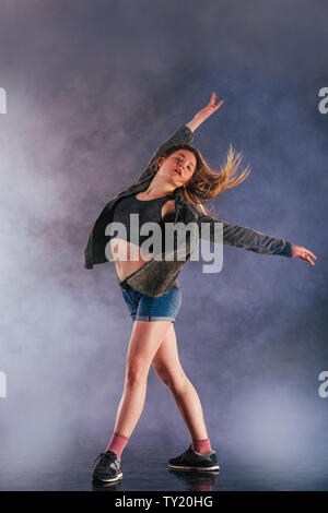 Tänzerin zeigt ihre Eleganz, indem sie ihr Bein hoch über den Kopf. Stockfoto