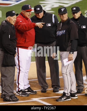 Los Angeles Engel Manager Mike Scioscia, Links, und Toronto Blue Jays Manager John Farrell geht über die Regeln, die mit dem Schiedsrichter im Angel Stadium in Anaheim, Kalifornien, April 8, 2011. Die Blue Jays gewann 2-1. UPI/Lori Shepler. Stockfoto