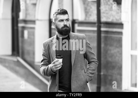 Man bärtige hipster Pappbecher Kaffee trinken. Noch ein Schluck Kaffee. Kaffee trinken für Unterwegs. Geschäftsmann lumbersexual Erscheinungsbild genießen Sie Kaffee Pause aus Business Center. Entspannen und erholen Sie sich. Stockfoto