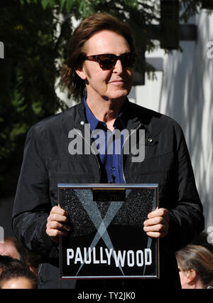 Ehemalige Beatle Paul McCartney hält eine spezielle Plakette präsentiert von Hollywood Handelskammer Präsident und CEO Leon Gubler wie McCartney wurde mit dem 2.460 th Stern auf dem Hollywood Walk of Fame geehrt, während einer enthüllungsfeier in Los Angeles am 9. Februar 2012. UPI/Jim Ruymen Stockfoto