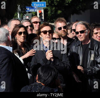 Ehemalige Beatle Paul McCartney (C) und seine Frau Nancy Shevell (L) hören Kommentare während einer enthüllungsfeier McCartney ehrt mit dem 2.460 th Stern auf dem Hollywood Walk of Fame in Los Angeles am 9. Februar 2012. Auf der Suche nach Rechts ist Musiker Neil Young. UPI/Jim Ruymen Stockfoto