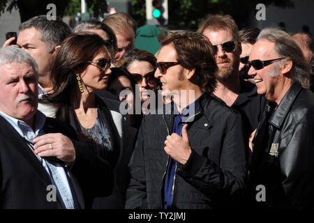 Ehemalige Beatle Paul McCartney (C) und seine Frau Nancy Shevell (L) hören Kommentare während einer enthüllungsfeier McCartney ehrt mit dem 2.460 th Stern auf dem Hollywood Walk of Fame in Los Angeles am 9. Februar 2012. Auf der Suche nach Rechts ist Musiker Neil Young. UPI/Jim Ruymen Stockfoto