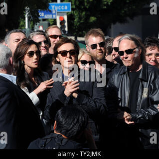 Ehemalige Beatle Paul McCartney (C) und seine Frau Nancy Shevell (L) hören Kommentare während einer enthüllungsfeier McCartney ehrt mit dem 2.460 th Stern auf dem Hollywood Walk of Fame in Los Angeles am 9. Februar 2012. Auf der Suche nach Rechts ist Musiker Neil Young. UPI/Jim Ruymen Stockfoto