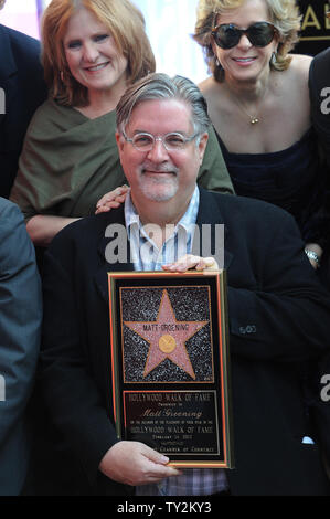 Matt Groening (C), der Schöpfer der am längsten laufenden Gescripteten Show im Fernsehen, hält eine Replik Plakette, nachdem er mit dem 2.459 th Stern auf dem Hollywood Walk of Fame geehrt wurde während einer enthüllungsfeier in Los Angeles am 14. Februar 2012. UPI/Jim Ruymen Stockfoto