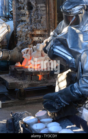 Arbeitnehmer in Brand Anzüge Formen aus dem Ofen nehmen geschmolzene Bronze Metall in ihnen während der Besetzung der Screen Actors Guild Award Statuetten zu gießen, an der amerikanischen Kunst Gießerei in Burbank, Kalifornien am 17. Januar 2013. Die Preise werden in Los Angeles am 27. Januar 2013 stattfinden. UPI/Jim Ruymen Stockfoto