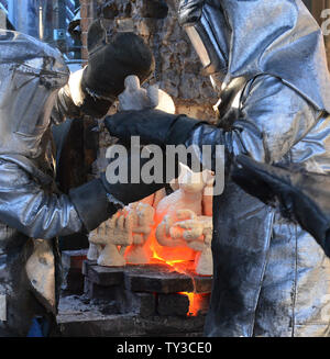 Arbeitnehmer in Brand Anzüge Formen aus dem Ofen nehmen geschmolzene Bronze Metall in ihnen während der Besetzung der Screen Actors Guild Award Statuetten zu gießen, an der amerikanischen Kunst Gießerei in Burbank, Kalifornien am 17. Januar 2013. Die Preise werden in Los Angeles am 27. Januar 2013 stattfinden. UPI/Jim Ruymen Stockfoto