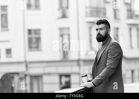 Man bärtige hipster Pappbecher Kaffee trinken. Noch ein Schluck Kaffee. Kaffeegenuss unterwegs. Geschäftsmann gepflegt aussehen genießen Sie Kaffee Pause aus Business Center. Entspannen und erholen Sie sich. Stockfoto