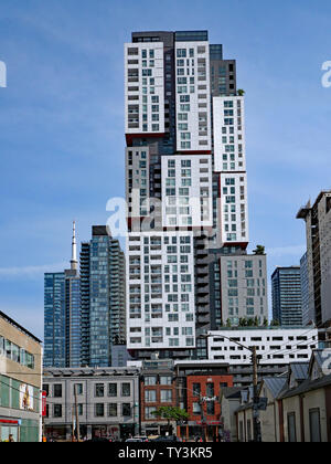 TORONTO - JUNI 2019: Eine bunte Mischung von Architektur in der Queen Street, das Hotel ist ein hohes, modernes Gebäude hinter kleinen Älteren. Stockfoto