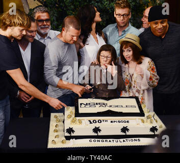 Darsteller Chris O'Donnell, Daniela Ruah, Miguel Ferrer, Barrett Foa, L.L. Cool J, Linda Hunt und Renee Felice Smith (L-R), werden von den Herstellern während eines Kuchen beigetreten - Cutting CBS''NCIS: Los Angeles' Verfilmung von ihren hundertsten Episode, am Set bei Paramount Studios in Los Angeles am 23. August 2013 zu feiern. UPI/Jim Ruymen Stockfoto