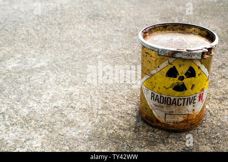 Strahlung Warnzeichen auf einem rostigen Paket des radioaktiven Materials Container auf dem rauen Beton Boden Stockfoto