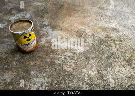 Strahlung Warnzeichen auf einem rostigen Paket des radioaktiven Materials Container auf dem rauen Beton Boden Stockfoto