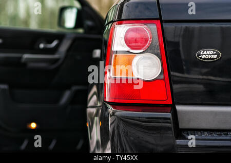 Grodno, Weißrussland, Dezember 2012: Land Rover Range Rover Sport V8-Kompressormotors. Linke hintere Scheinwerfer von schwarzen SUV geschossen Close-up mit geöffneter Tür aus f Stockfoto