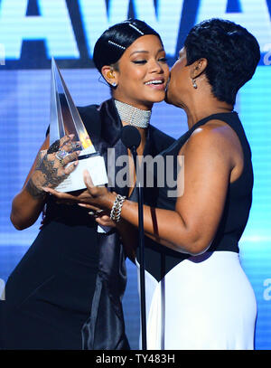 Rihanna übernimmt erste Symbol Award der AMA von ihrer Mutter Monica Braithwaite bei der 41st jährlichen American Music Awards bei Nokia Theatre L.A. statt Leben in Los Angeles am 24 November, 2013. UPI/Jim Ruymen Stockfoto