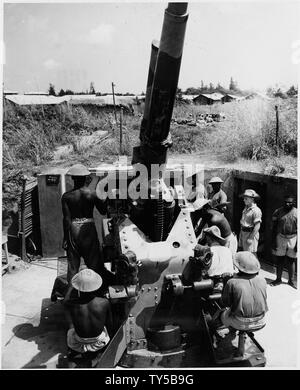 Schutz gegen mögliche feindliche Luftangriffe, britische Truppen sind Ausbildung Afrikanischen Eingeborenen in anti-aircraft Einheiten. Die instructors, Veteranen der Batlle von Großbritannien, haben die eingeborenen apt Studenten gefunden und unter Feuer cool. Eine Afrikanische Einheit gezeigt wird das Laden eines der 3,7 mm. ack-ack-Gewehren unter der Aufsicht der britischen N.C.O.s und Unteroffizieren. Stockfoto