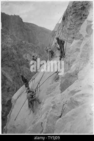 High-scalers bei der Arbeit auf der Arizona Einlaß towers Lage rund 550' über dem Niveau des Colorado River. Der Hintergrund ist der Nevada Seite des Canyon.; Umfang und Inhalt: Foto aus Band 2 einer Reihe von Fotoalben dokumentiert den Bau des Hoover Dam, Boulder City, Nevada. Stockfoto